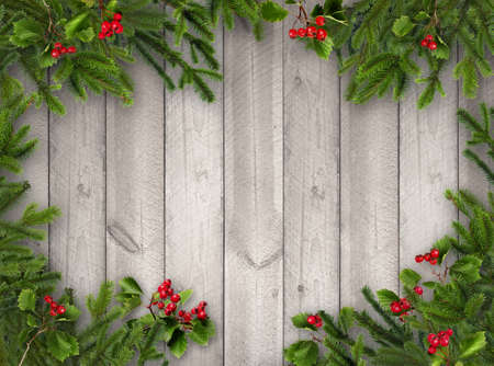 Green Christmas tree branches and red hawthorn berries on grey wooden vertical plank wall backgroundの写真素材