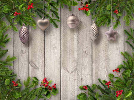 Green Christmas tree branches, red hawthorn berries and silver decoration balls on grey wooden vertical plank wall backgroundの写真素材