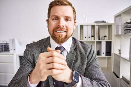 Mid age businessman talking on video call at the office