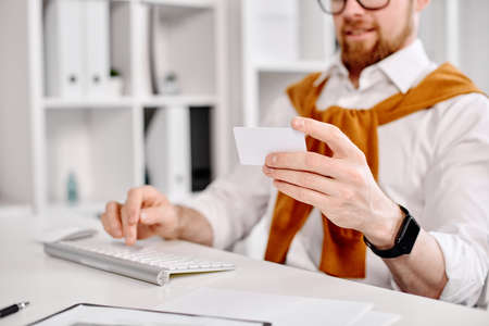 Mid age businessman working with plastic card at the computer in the officeの写真素材