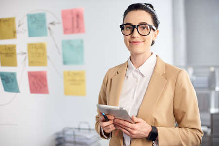 mid age businesswoman working on new project at modern office with a tabletの写真素材