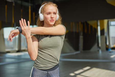 Girl in sports wear does warmnig up before the training.の写真素材