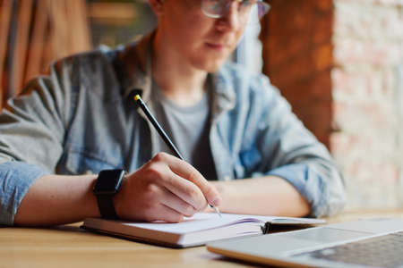 Young man works on the laptop in the cafe.の写真素材