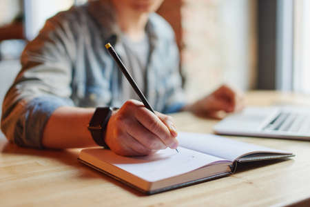 Man making notes in the textbook.の写真素材