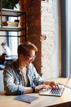 Young man works on the laptop in the cafe.の写真素材