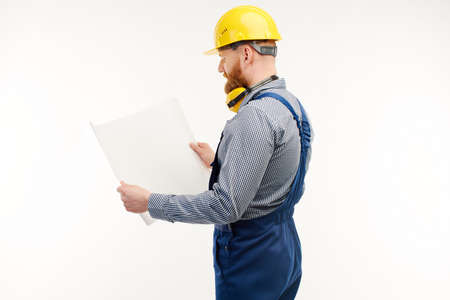 engineer looking at a drawing on a white background. Stand back to camera.