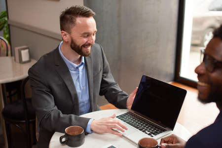 Businessman explains to another contract terms at lunchの写真素材