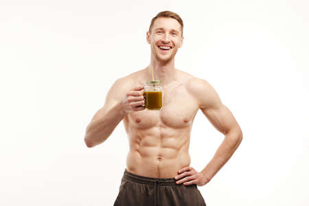 The athlete drinks a healthy smoothie on a white background