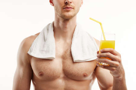 Close up of a man drinking orahje juice from a clear glass with a straw.の写真素材