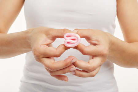 Close up of a girl folding pink menstrual cup.の写真素材