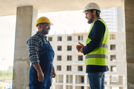 Two engineers discuss work related questions together.
