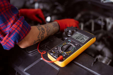 Close up of a woman fixing a big truck which is broken.