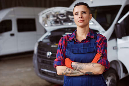 Female auto mechanic in overalls poses at the camera.の写真素材