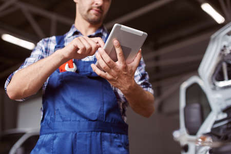 Close up of the mechanic working with the tablet.の写真素材