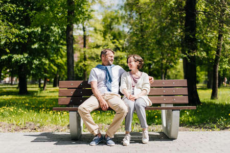 Middle-aged married couple resting in the park shot from distance.の写真素材