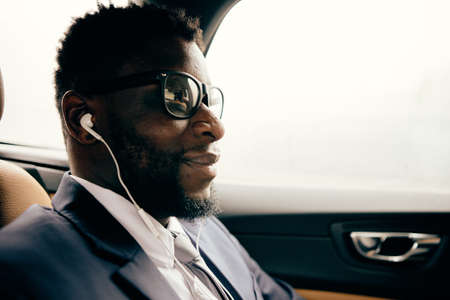 Portrait of a man in the car using his headphones.
