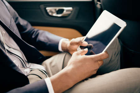 Close up of a man scrolling through tablet screen.の写真素材