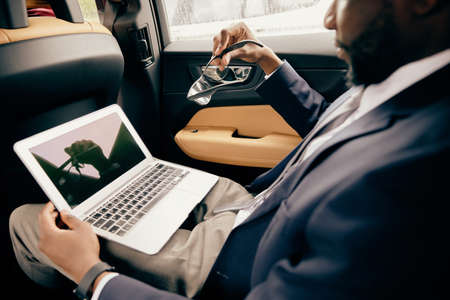 Close up of a businessman with his glasses off looking at the laptop screen.