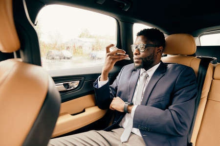 Man on back car seat talks on the phone and looks out of the window.の写真素材