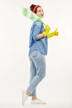 Pretty woman in work-wear holds a green duster.