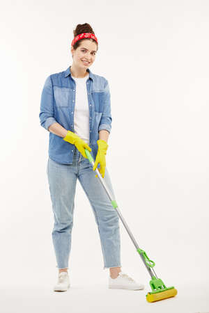 Pretty woman in work-wear holds a green mop.