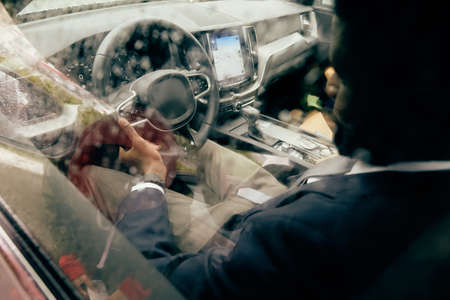 Driver holding steering wheel ready to drive the car he owns.の写真素材