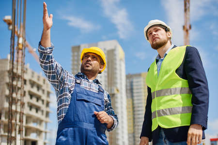 Two engineers discuss work related questions together.