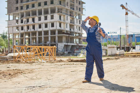 An engineer on the construction point holds work related equipment.