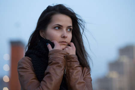 Girl with a scarf freezing in the cityの写真素材