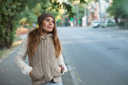 Beautiful woman in knitted dress walking in the cityの写真素材