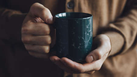 Cup of tea warm hands. Vintage style.の写真素材