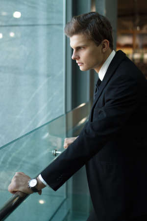 Stylish man black jacket standing in boutiqueの写真素材