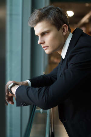 Stylish man black jacket standing in boutiqueの写真素材