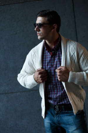 Fashion photo of stylish man in checkered shirt, sunglasses and white pulloverの写真素材