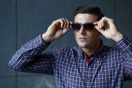 Stylish man in checkered shirt dress sunglassesの写真素材