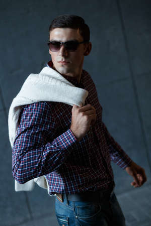 Fashion photo of stylish man in checkered shirt and sunglasses with pulloverの写真素材