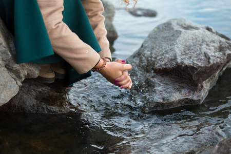 Woman wash her hands in river