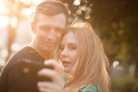 Young couple take self picture in parkの写真素材