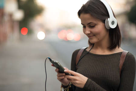 Young woman listening to music in the cityの写真素材