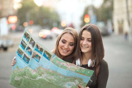 Young girlfriends watching the city mapの写真素材