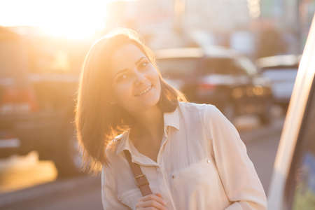 Portrait of pretty girl in city. Beautiful soft light at sunset.の写真素材