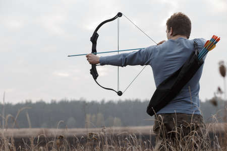 Man hunter shot with bow in open air on field