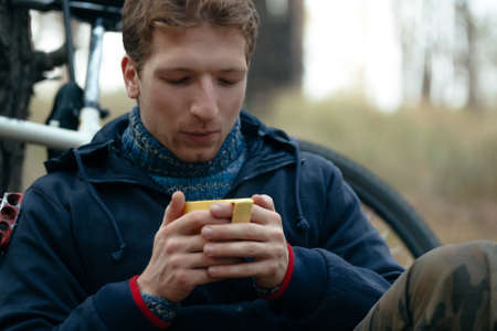 Man tourist sitting and drinking tea in forestの写真素材