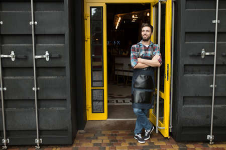 Young shop owner standing at the entranceの写真素材