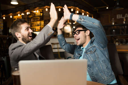 Happy lucky friends in a cafe sit at table