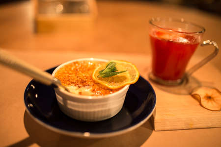 Sweet dessert and cranberry tea on a table in the cafe at nightの写真素材