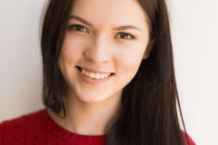 Portrait of a smiling pretty woman at the wall