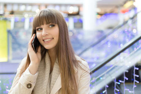 Young woman talk to cellphone at hall of mallの写真素材