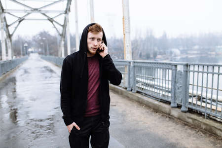 Sporty man talking on the phone on ? bridgeの写真素材