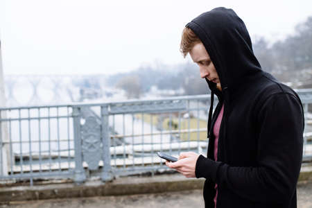 Sporty man using his mobile phone on bridgeの写真素材